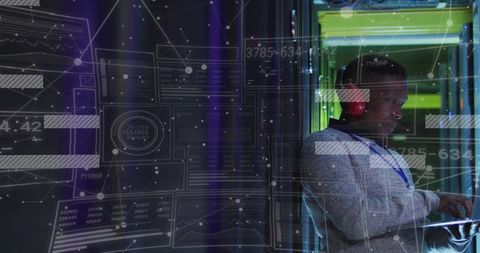 Monitoring Technician Using Laptop at Server Rack with Futuristic HUD Overlay Neon Lights