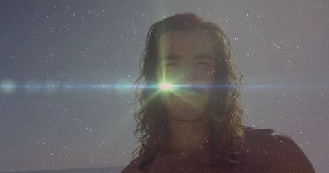Sunlit Man with Long Hair at Beach