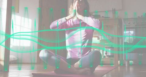 Woman practicing breathwork in sunlit kitchen on yoga mat with teal waveform overlay