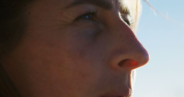 Close-up of Serious Woman's Face in Sunlight with Blue Sky Background - Download Free Stock Images Pikwizard.com