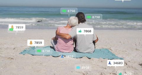Senior couple connecting digitally while relaxing on beach