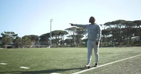 Soccer coach planning strategy on field for practice session
