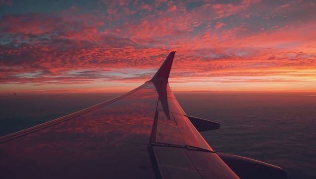 Airplane Wing with Reflected Sunset During Flight