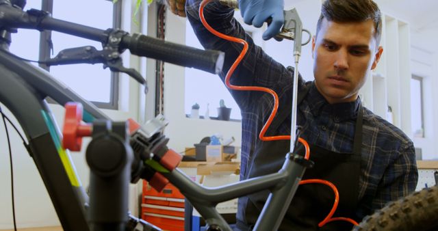Caucasian man repairs a bicycle in a workshop. He's focused on tuning the bike's brakes, showcasing his mechanical skills.