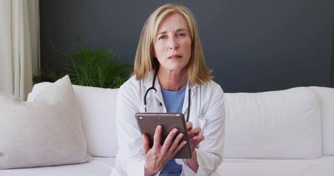 Mature Female Doctor Consulting from Home with Tablet for Telemedicine and Virtual Care