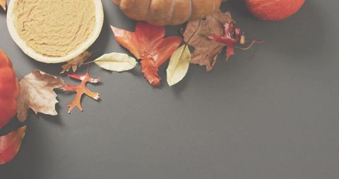 Autumn harvest flatlay featuring pumpkin pie, pumpkins, apple and colorful leaves