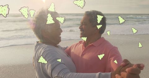 Senior Couple Dancing Joyfully on Beach with Christmas Motif