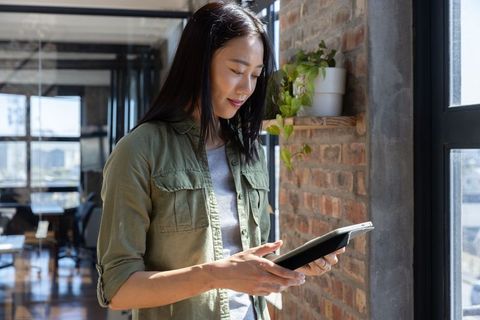 Professional woman using tablet in modern urban office
