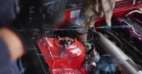 Mechanic inspecting red strut tower with digital diagnostics overlay in automotive workshop