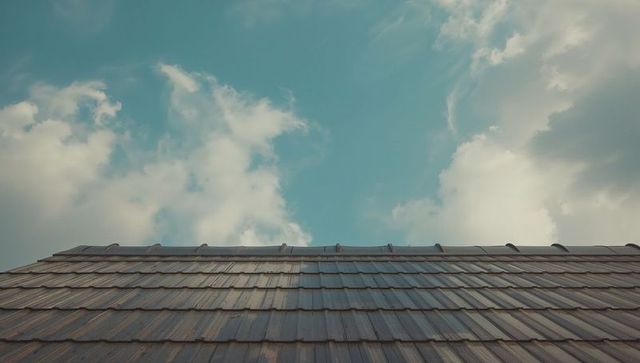 Rustic rooftop with overlapping tiles under blue sky