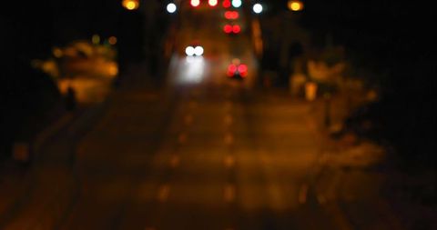 Bokeh of Car Lights on Dark City Street at Night