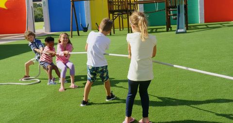 Children Playing Tug of War on Sunny School Playground