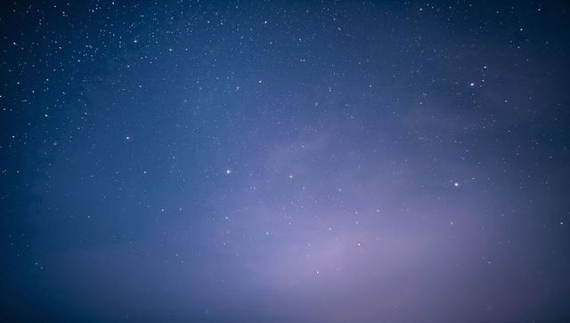 Vast starfield with faint milky way and soft purple-blue horizon glow for cosmic art