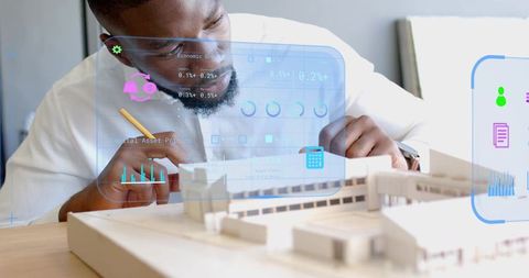 Architect adjusting scale model with augmented reality visualization and analytics overlay