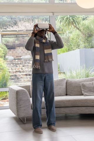 African american man exploring virtual reality headset in contemporary minimalist living room