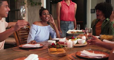 Diverse Friends Celebrating with Laughter and Toasts at Dinner Party