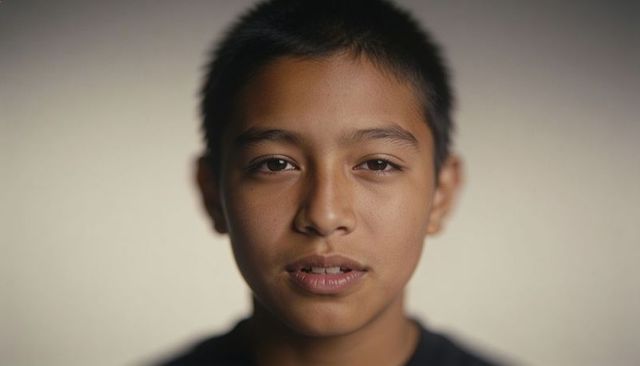 Holding gaze teen closeup headshot with warm soft light and neutral backdrop