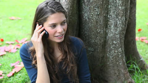 Woman Relaxing with Phone Conversation in Park Scene