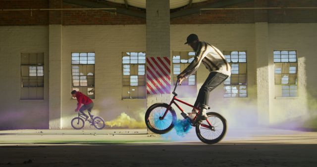 BMX Riders Performing Stunts in Abandoned Warehouse with Color Fog - Download Free Stock Images Pikwizard.com