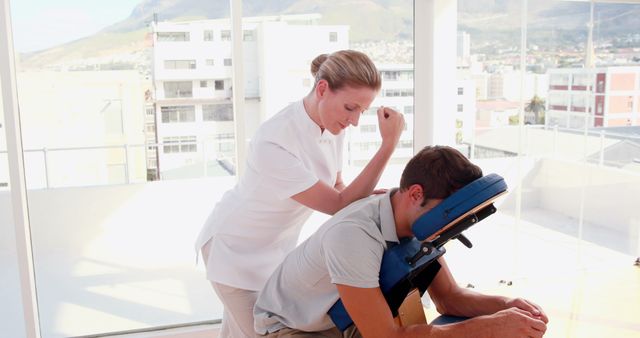 Massage Therapist Providing Relaxing Chair Massage in Light-Filled Room - Download Free Stock Images Pikwizard.com