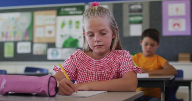 Focused Young Girl Writing in Classroom, Concentrated on Assignment - Download Free Stock Images Pikwizard.com