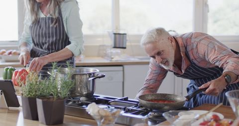 Middle-aged couple enjoying cooking home meal together