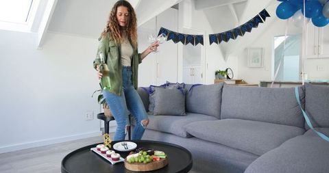 Woman Celebrating Birthday at Home with Decorations and Snacks