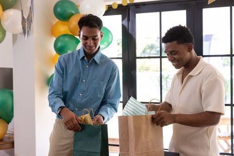 Diverse Friends Opening Gifts in Festive Indoor Celebration