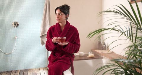 Woman Relaxing in Chic Bathroom Robe with Tea