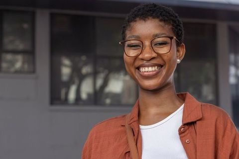 Confident african american woman smiling outdoors with glasses headshot for branding