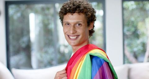 Joyful Young Man Embracing LGBTQ Pride with Rainbow Flag