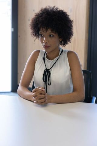 Businesswoman confidently sitting at modern office table