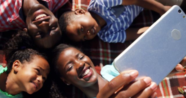 Smiling Family Taking Selfie while Lying on Picnic Blanket Outdoors - Download Free Stock Images Pikwizard.com