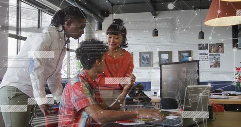 Collaborative team working at modern open office desk with digital data overlay and tech
