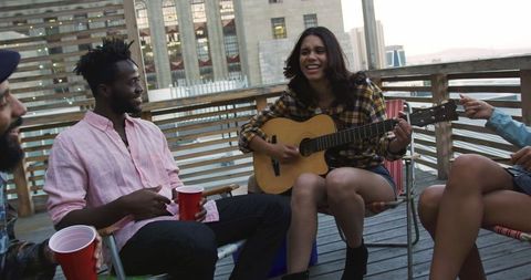 Young Friends Enjoying Rooftop Party with Music