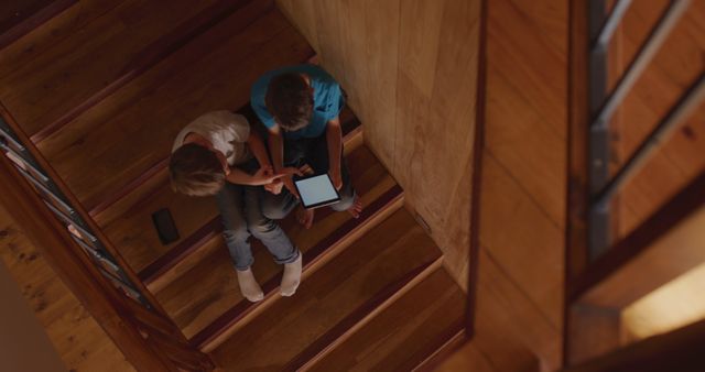 Top View Children Engaging with Tablet on Wooden Staircase - Download Free Stock Images Pikwizard.com