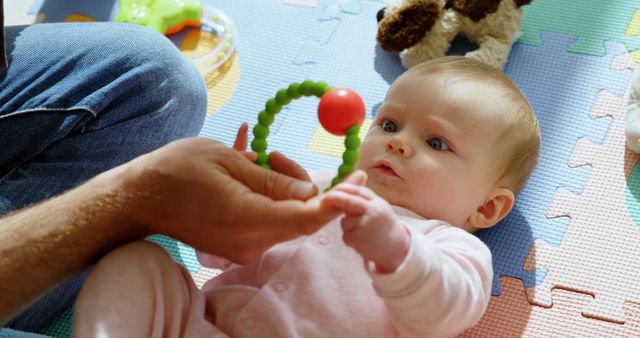 Baby Playing With Toy While Lying On Floor With Parent - Download Free Stock Images Pikwizard.com