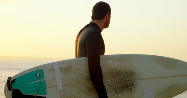 Surfer Holding Board at Sunset Beach Ready to Catch Waves - Download Free Stock Images Pikwizard.com