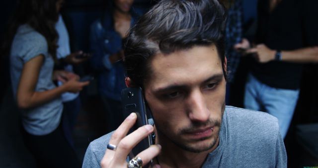 Stressed Young Man Taking Phone Call at Social Gathering - Download Free Stock Images Pikwizard.com