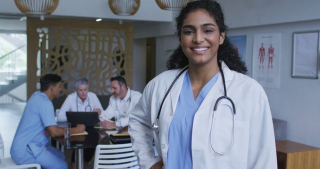 Smiling Female Doctor in Hospital with Team Collaboration in Background - Download Free Stock Images Pikwizard.com