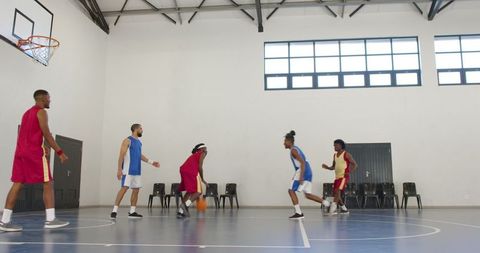 Inclusive Team Playing Basketball in Modern Indoor Court