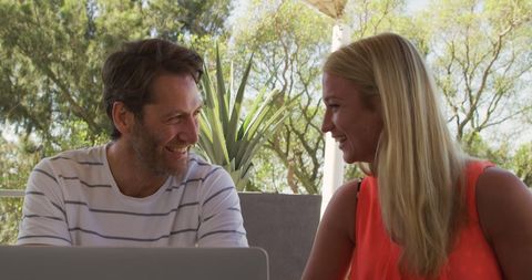 Happy Couple Relaxing Outdoors with Laptop