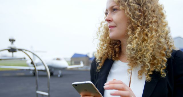 Businesswoman with Curly Hair Waiting at Private Airport - Download Free Stock Images Pikwizard.com