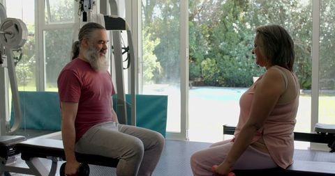 Senior Couple Exercising with Dumbbells in Home Gym for Fitness and Wellness