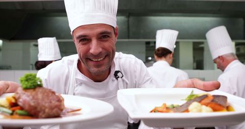 Smiling Chef Presenting Gourmet Dishes in Professional Kitchen - Download Free Stock Images Pikwizard.com