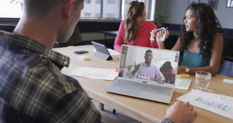 Diverse Team Collaborating Over Video Call in Modern Office