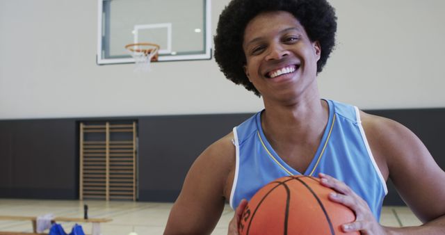 Happy basketball player holding ball in gym - Download Free Stock Images Pikwizard.com