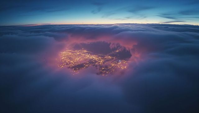 City Lights Visible Through Mystical Cloud Opening at Twilight