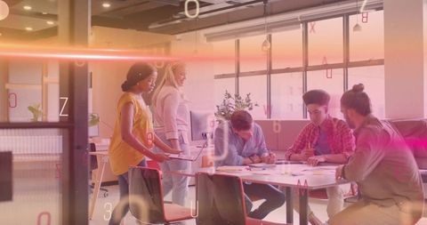 Diverse team collaborating and brainstorming around table in modern open-plan office