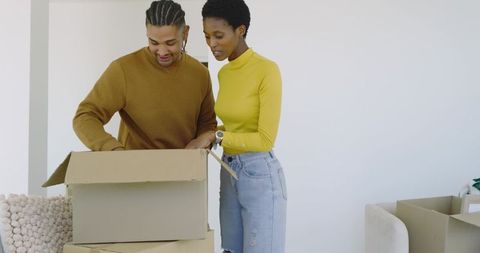 Couple unpacking boxes in new home with minimalist interior